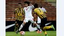 Pemain UEA, Omar Abdulrahman (tengah), berusaha melewati hadangan pemain Malaysia dalam Kualifikasi Piala Dunia 2018 di Stadion Shah Alam, Malaysia, (17/11/2015). Malaysia kalah 1-2 dari UEA. (AFP Photo/Manan Vatsyayana)