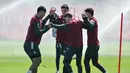 Mereka saling memegang ujung pulpen satu sama lain dan berjalan dengan menggiring bola di dalam lingkaran sambil mengoper. (AFP/Glyn Kirk)