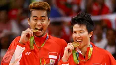 Pasangan ganda campuran Indonesia, Tontowi Ahmad dan Liliyana Natsir mengigit medali emas usai mengalahkan lawannya asal Malaysia Peng Soon Chan dan Liu Ying Goh pada final bulutangkis di Riocentro Pavilion 4 , Brasil. (REUTERS/Mike Blake)