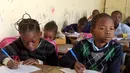 Dua murid saat menghadiri kelas di sekolah dasar di Pikine, di pinggiran Dakar, (30/1). Beberapa kepala negara, termasuk presiden Prancis dan Presiden Senegal mensponsori pertemuan tersebut. (AFP Photo/Seyllou)