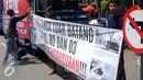 Seorang pemuda kampung Luar Batang memasang spanduk tulisan saat melakukan aksi di depan Balai Kota Jakarta, Jumat (22/4/2016). Mereka mempertanyakan kebijakan Pemprov DKI Jakarta yang melakukan penggusuran. (Liputan6.com/Helmi Fithriansyah)