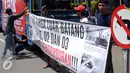 Seorang pemuda kampung Luar Batang memasang spanduk tulisan saat melakukan aksi di depan Balai Kota Jakarta, Jumat (22/4/2016). Mereka mempertanyakan kebijakan Pemprov DKI Jakarta yang melakukan penggusuran. (Liputan6.com/Helmi Fithriansyah)