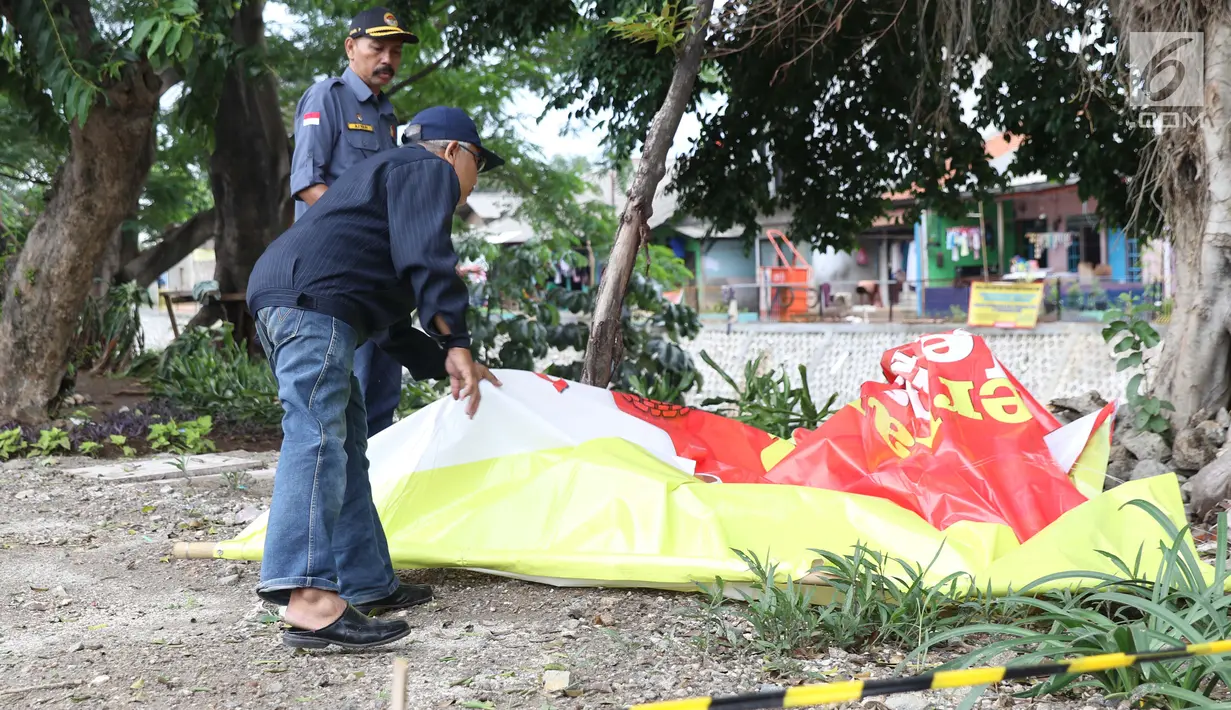 Petugas Panwaslu Kecamatan Ciracas mengamankan APK usai diturunkan di Jalan Raya Bogor dekat GOR Ciracas, Jakarta, Rabu (23/1). Penurunan APK ini karena pemasangannya dianggap melanggar ketentuan. (Liputan6.com/Helmi Fithriansyah)