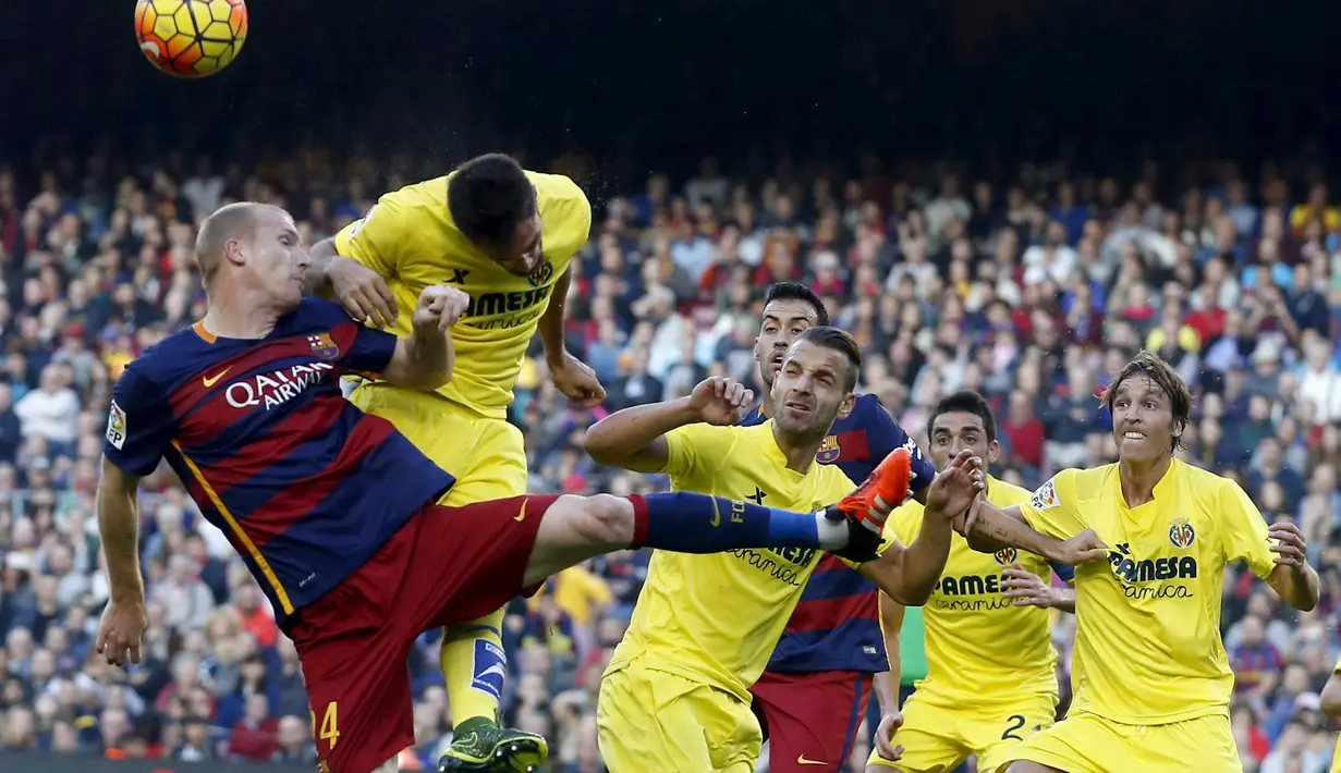 Pemain Barcelona Jeremy Mathieu (kiri) berebut bola dengan para pemain Villarreal  pada lanjutan La Liga Spanyol di Stadion Camp Nou, Barcelona, Spanyol, MInggu (8/11/2015). (REUTERS/Albert Gea)