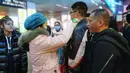 Petugas memeriksa suhu tubuh seorang penumpang di Stasiun Kereta Api Yingtan di Nanchang di Provinsi Jiangxi Tengah, China (22/1/2020). Sebanyak 17 orang meninggal akibat terinfeksi virus corona. (AFP Photo/STR)