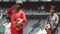 Atlet lompat jauh Indonesia, Rica Oktavia, hormat bendera saat seremoni usai meraih medali emas Asian Para Games 2018 di SUGBK, Jakarta, Senin (8/10/2018). (Bola.com/Vitalis Yogi Trisna)