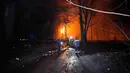 Serangan udara ini menargetkan infrastruktur energi serta menghancurkan sejumlah gedung apartemen warga sipil. Tampak dalam foto, orang-orang berdiri di luar gedung yang terbakar setelah serangan Rusia di Kryvyi Rih, Ukraina, Kamis, 8 Januari 2026. (AP Photo/Mykola Myrnyi)