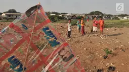 Anak-anak bermain layang-layang di tanah sengketa kawasan Pedongkelan, Jakarta, Kamis (11/7/2019). Meski bertempat tinggal di atas lahan sengketa, anak-anak setempat memanfaatkan tanah kosong yang penuh semak belukar tersebut sebagai sarana bermain ketika sore hari. (merdeka.com/Iqbal S. Nugroho)