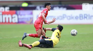 Pemain Persija Jakarta, Aji Kusuma, melewati kiper PSM Makassar, Reza Arya, pada laga pekan ke-20 BRI Liga 1 2022/2023 di Stadion Patriot Candrabhaga, Bekasi, Rabu (25/1/2023). Persija menang dengan skor 4-2. (Bola.com/M Iqbal Ichsan)