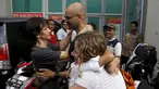 Ferdinant Tjiong (kiri) dan Neil Bantleman ditemani para istri berpelukan di depan penjara Cipinang, Jakarta (14/8/2015). Dua guru Jakarta International School (JIS) Ferdinant dan Neil diputus bebas oleh Pengadilan Tinggi Jakarta. (REUTERS/Beawiharta)