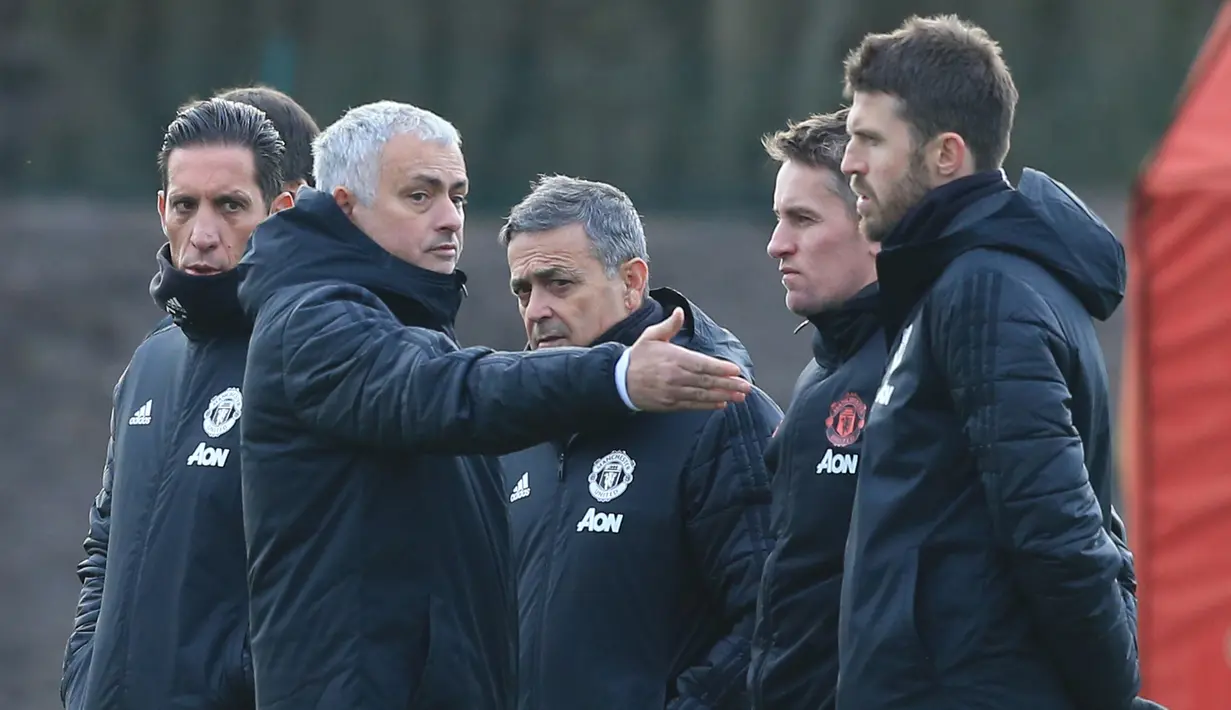 Pelatih Manchester United, Jose Mourinho berbincang dengan asissten pelatih selama sesi pelatihan tim di kompleks Pelatihan Carrington, Inggris (11/12). Saat ini MU berada di posisi kedua di grup tersebut dengan poin sepuluh. (AFP Photo/Lindsey Parnaby)