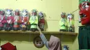 Perajin, merapikan miniatur ondel-ondel dari botol plastik di rumah produksi Kramat Jati, Jakarta, Rabu (28/11). Miniatur yang terbuat dari plastik diproduksi 50-80 buah dengan omset 5-8 Juta perbulan. (Liputan6.com/Herman Zakharia)
