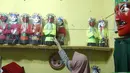 Perajin, merapikan miniatur ondel-ondel dari botol plastik di rumah produksi Kramat Jati, Jakarta, Rabu (28/11). Miniatur yang terbuat dari plastik diproduksi 50-80 buah dengan omset 5-8 Juta perbulan. (Liputan6.com/Herman Zakharia)