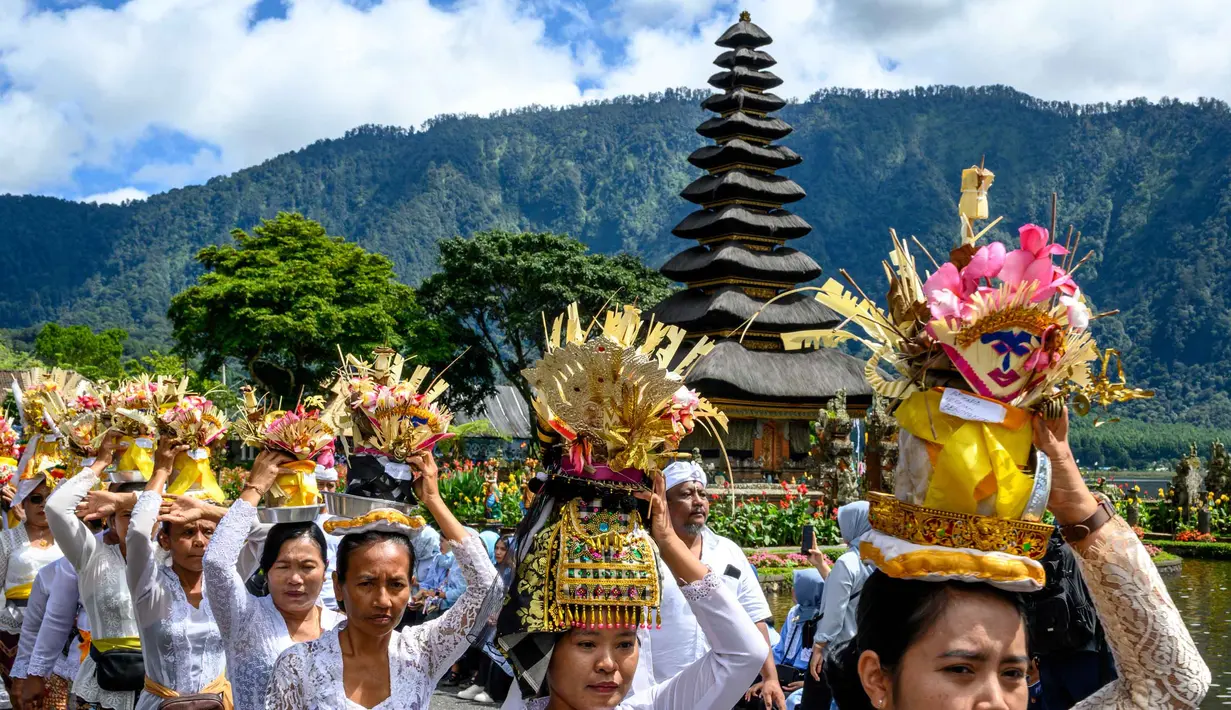 Daya tarik utama terletak pada dua pura yang paling menonjol, yakni Pelinggih Teling Segara dengan meru bertumpang 11 dan Pelinggih Linggah Ulun Danu dengan meru bertumpang tiga, yang terlihat mengambang di danau. Tampak dalam foto, umat Hindu bersiap mengikuti prosesi keagamaan di Pura Ulun Danu Beratan, sebuah pura Hindu di Danau Beratan dekat Bedugul, Bali, pada Jumat 7 November 2025. (Mladen ANTONOV/AFP)