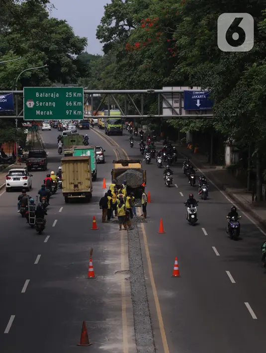 Pekerja melakukan penataan di ruas jalan nasional di Jalan Daan Mogot, Kota Tangerang, Banten, Selasa (15/2/2022). Pemkot Tangerang berencana melakukan sistem satu arah di Jalan Daan Mogot untuk mengatasi kemacetan di akses masuk tol Cengkareng-Batu Ceper-Kunciran. (Liputan6.com/Angga Yuniar)
