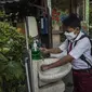 Seorang siswa mencuci tangan sebelum memasuki sekolah sebelum mengikuti pembelajaran tatap muka (PTM) di sebuah sekolah di Surabaya, Jawa Timur, Senin (6/9/2021). Pemerintah kembali membuka sekolah di tengah pandemi COVID-19. (JUNI KRISWANTO/AFP)