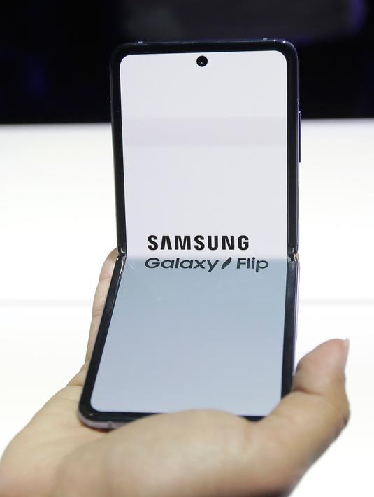 Seorang pekerja Samsung mendemonstrasi Galaxy Z Flip yang ditampilkan pada acara Unpacked 2020 di San Francisco, Selasa (11/2/2020). Selain itu juga pada bagian depan, Samsung juga menyematkan kamera memungkinkan pengguna memotret diri tanpa membuka smartphone. (AP/Jeff Chiu)