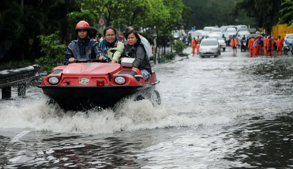 Warga dibantu mobil amfibi melewati genangan air di depan kampus UKRIDA, Jakarta, Selasa (21/1). Hujan deras sejak malam tadi, membuat sejumlah wilayah Jakarta tergenang air banjir. (Liputan6.com/Gempur M Surya)