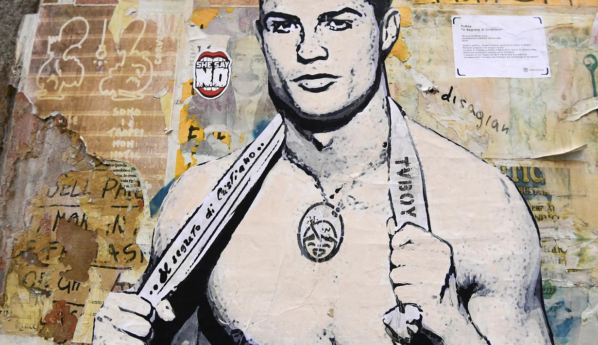 Sebuah mural dengan gambar bintang Juventus, Cristiano Ronaldo, yang terdapat di Milan, Senin (19/3). Mural berjudul Cristiano's Secret ini karya seniman Italia, TvBoy. (AFP/Miguel Medina)