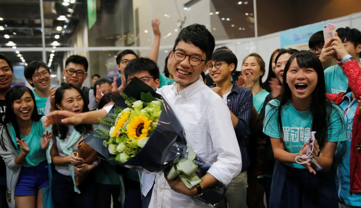 Nathan Law (tengah) merayakan kemenangannya usai mendapat kursi dalam pemilihan Dewan Legislatif Hong Kong, Senin (5/9). Ini adalah pertama kalinya kekuasaan politik Hong Kong memberikan tempat kepada aktivis muda prodemokrasi. (REUTERS / Tyrone Siu)