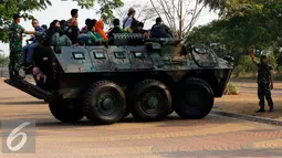 Sejumlah warga menaiki Panser Anoa milik TNI AD di pameran road to campus Alutsista di kawasan Boulevard UI, Jawa Barat, Kamis (27/8/2015). TNI AD menampilkan sejumlah peralatan dan persenjataan di pameran tersebut. (Liputan6.com/Yoppy Renato)