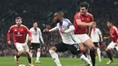 Pemain Manchester United, Harry Maguire berusaha merebut bola dari kaki pemain Lyon, Alexandre Lacazette dalam laga leg 2 perempat final Liga Europa 2024/2025 di Old Trafford, Manchester, Inggris, Jumat (18/04/2025) WIB. (AFP/Oli Scarff)