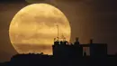 Bulan purnama terbit di atas Marseille, Prancis, 14 Juni 2022. Fenomena ini disebut juga sebagai Strawberry Supermoon karena terjadi pada saat panen strawberry. (AP Photo/Daniel Cole)