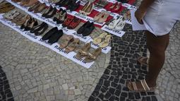 Di sepanjang Pantai Copacabana, pengunjuk rasa memasang 722 pasang sepatu perempuan, mulai dari sepatu hak tinggi hingga sepatu kets. (Tercio TEIXEIRA / AFP)