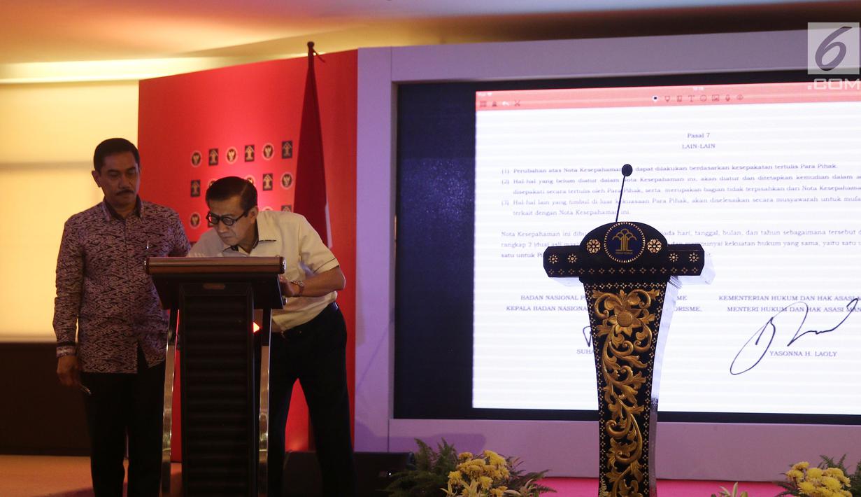 Kepala BNPT Suhardi Alius menyaksikan Menkumham Yasonna Laoly saat menandatangani kerja sama di gedung Kemenkumham, Jakarta, Kamis (31/5). Kerja sama tersebut terkait dengan penanggulangan tindak pidana terorisme. (Liputan6.com/Herman Zakharia)