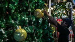Pekerja memasang ornamen pohon Natal di Thamrin 10, Jakarta, Selasa (22/12/2020). Pohon Natal akan dipasang pada 23 Desember hingga 1 Januari mendatang. (Liputan6.com/Faizal Fanani)