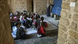Anak-anak Palestina menghadiri kelas di sekolah bersejarah "Al-Kamaliya al-Othmanya" di Kota Tua Gaza yang menjadi bagian dari inisiatif sukarelawan yang diorganisir oleh para guru pengungsi, di Kota Gaza pada 2 November 2025. Anak-anak pengungsi Palestina di Gaza akan secara bertahap kembali ke sekolah. (Omar AL-QATTAA/AFP)