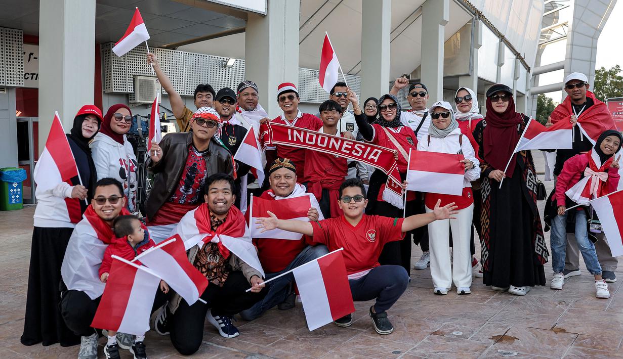 Sekelompok suporter Indonesia berfoto di luar stadion sebelum dimulainya laga kedua Grup D Piala Asia 2023 antara Timnas Indonesia menghadapi Vietnam di Abdullah Bin Khalifa Stadium, Doha, Qatar, Jumat (19/1/2024). (AFP/Karim Jaafar)
