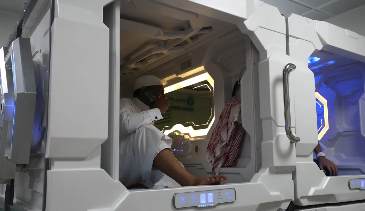 Seorang pria Arab Saudi menggunakan fasilitas kamar kapsul di Makkah, 16 Agustus 2018. Kapsul dapat ditempatkan berdampingan atau di atas satu sama lain, dengan ketinggian dua unit. (AFP/AHMAD AL-RUBAYE)