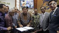 Menko Perekonomian Airlangga Hartarto disaksikan Menko Polhukam Mahfud MD, Menkumham Yasonna Laoly, dan Wakil Ketua Baleg DPR M. Nurdin menandatangani draft Peraturan Pemerintah Pengganti Undang-Undang (Perppu) Cipta Kerja di Kompleks Parlemen, Senayan, Jakarta, Rabu (15/2/2023). Baleg DPR menyetujui untuk membawa Perppu Cipta Keria ke Paripurna dan disahkan menjadi Undang-Undang (UU). (Liputan6.com/Faizal Fanani)