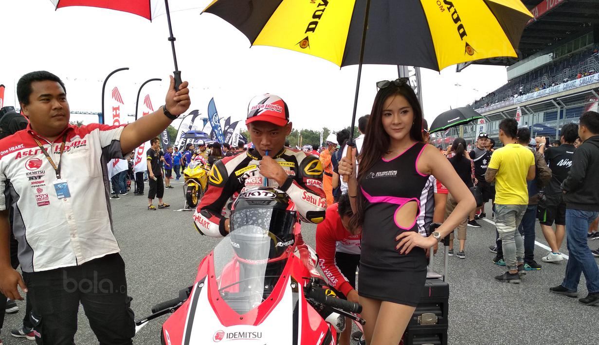 Para Umbrella Girl memayungi pebalap saat Asia Road Racing Championship (ARRC) 2017 di Sirkuit Buriram, Thailand, Sabtu (2/12/2017). Kehadiran para umbrella girl menjadi daya tarik tersendiri di lintasan balap. (Bola.com/Muhammad Wirawan)