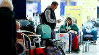 Seorang pelancong memeriksa ponselnya selama badai musim dingin di Bandara Internasional Denver di Denver, Colorado, Rabu (22/2/2023). Lebih dari 1.000 penerbangan telah dibatalkan di seluruh Amerika Serikat (AS) karena badai berdampak pada perjalanan di seluruh negeri. (Michael Ciaglo/Getty Images/AFP)