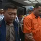 Polisi mengawal tersangka kasus penyiramanan air keras terhadap penyidik senior KPK Novel Baswedan di Polda Metro Jaya, Jakarta, Sabtu (28/12/2019). Tersangka berinisial RM dan RB dipindahkan dari Polda Metro Jaya ke Bareskrim Mabes Polri untuk penyidikan lebih lanjut. (merdeka.com/Imam Buhori)