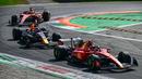 Pembalap Red Bull Racing, Max Verstappen (tengah) memacu mobilnya di belakang pembalap Ferrari, Carlos Sainz saat balapan Formula 1 GP Italia 2023 yang berlangsung di Sirkuit Monza, Italia, Minggu (03/09/2023). Verstappen memulai balapan dari posisi kedua. (AFP/Ben Stansall)