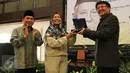 Presiden PKS Mohamad Sohibul Iman bersama Ketua Fraksi PKS DPR Jazuli Juwaini memberikan plakat kepada putri Kasman Singodimedjo, Prof Dr drg Dewi Nurul Istiqomah usai acara seminar dan buka puasa di Jakarta, Kamis (16/6). (Liputan6.com/Fery Pradolo) 