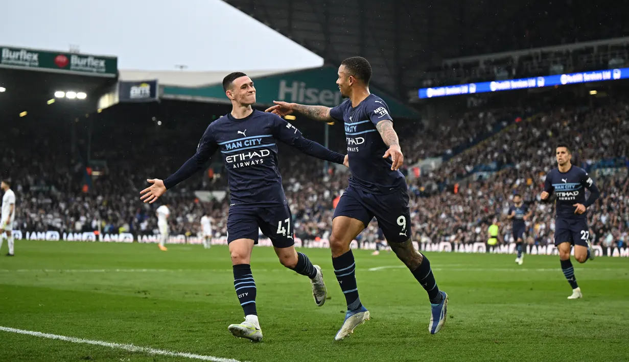 <p>Striker Manchester City, Gabriel Jesus (tengah) berselebrasi dengan gelandang Phil Foden setelah mencetak gol ke gawang Leeds United pada pertandingan lanjutan Liga Inggris di Elland Road di Leeds, Inggris utara (30/4/2022). The Citizens yang mengoleksi 83 poin berada di atas The Reds dengan 82 poin. (AFP/Oli Scarff)</p>