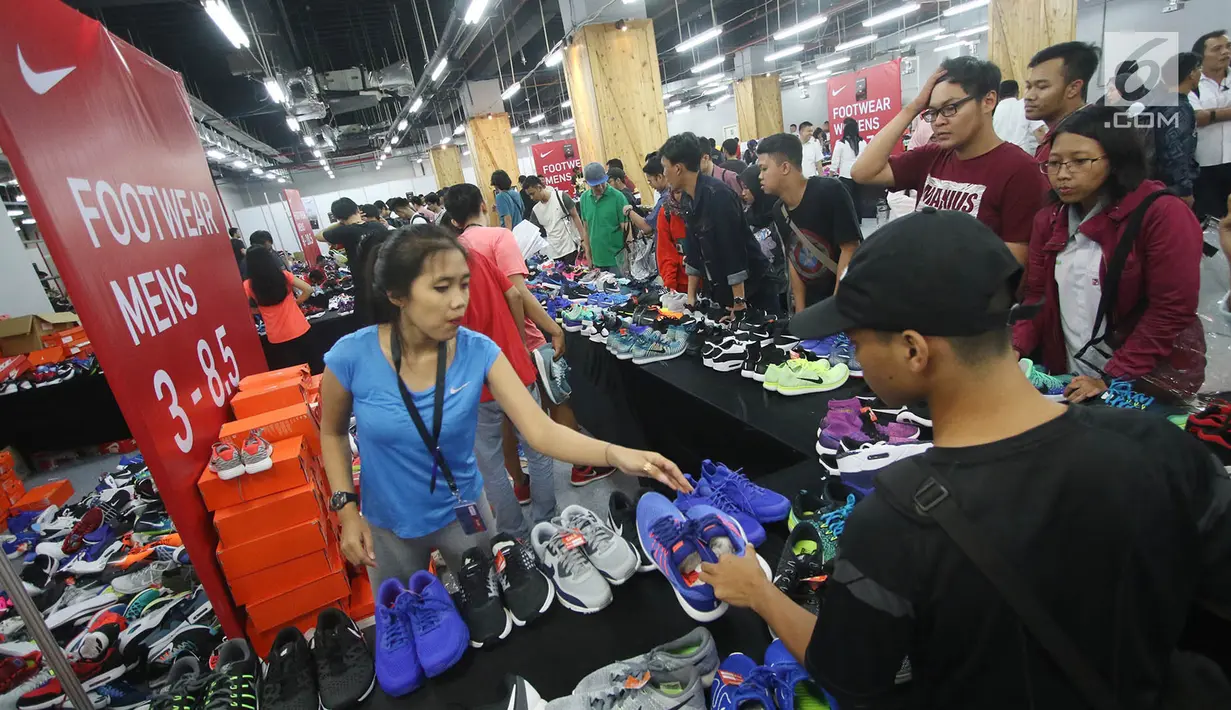 Pramuniaga melayani pengunjung yang membeli sepatu dalam Nike Bazaar di Mal Grand Indonesia, Jakarta, Rabu (23/8). Nike memberi diskon hingga mencapai 90 persen untuk semua produk sepatu lelaki dan perempuan. (Liputan6.com/Immanuel Antonius)