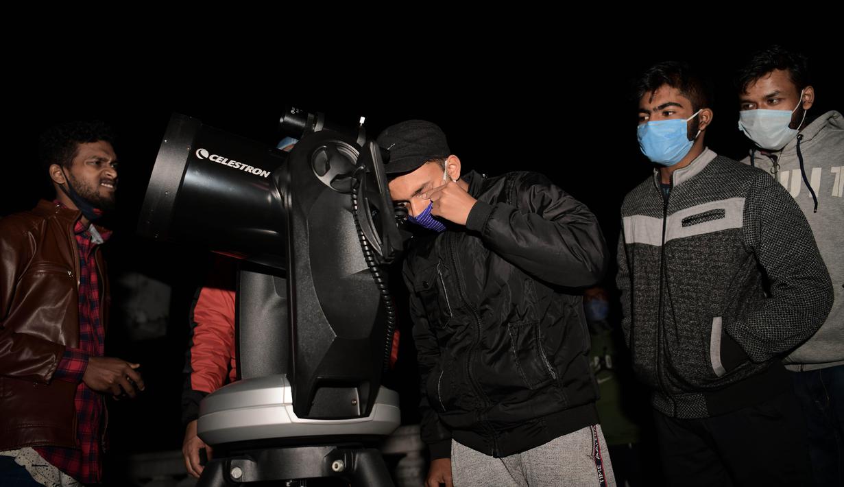 Seorang pria menyaksikan fenomena "konjungsi besar" planet Jupiter dan Saturnus di Udaipur, 50 kilometer dari Agartala, ibu kota Negara Bagian Tripura, India timur laut (22/12/2020). Konjungsi Besar Jupiter-Saturnus disebut langka karena hanya akan terjadi setiap 19 hingga 20 tahun sekali. (Xinhua/S