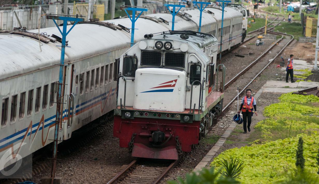 Petugas berjalan disamping kereta api di Stasiun Tanjung Priok, Jakarta Utara, Kamis (6/4). Acara HUT tersebut diselenggarakan oleh  PT Kereta Api Indonesia (KAI) Daop 1 bersama dengan Komunitas Pecinta Kereta Api Indonesia. (Liputan6.com/Gempur M. Surya)