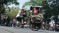 Salah seorang peserta lomba balap becak melakukan atraksi mengangkat roda. (Liputan6.com/Huyogo Simbolon)