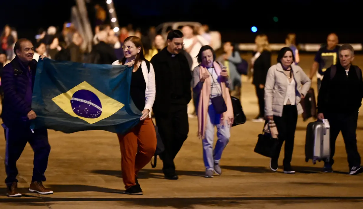 Warga negara Brasil yang melarikan diri dari konflik antara Israel dan Hamas turun dari pesawat militer di Pangkalan Udara Brasilia dalam penerbangan penyelamatan pertama pemerintah Brasil dari Tel Aviv, Rabu (11/10/2023). (EVARISTO SA / AFP)