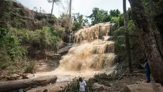 Warga berada di dekat air terjun Kintampo, Ghana (21/3). 20 siswa tewas setelah pohon tumbang dan menimpa mereka yang tengah berada di kolam air terjun pada Minggu (19/3) waktu setempat. (AFP Photo / Cristina Aldehuela)