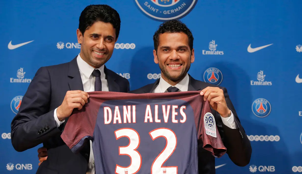 Dani Alves berpose dengan Presiden PSG Nasser Al-Khelaifi saat konferensi pers di stadion Parc des Princes di Paris, Prancis, (12/7). Alves akan mengenakan seragam nomor punggug 32, sama seperti yang dipakainya di Juventus. (AP Photo/Michel Euler)