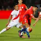 Penyerang Chile, Alexis Sanchez (tengah) berusaha melewati dua pemain Peru pada Kualifikasi Piala Dunia 2018 di National Stadium, Santiago, Chile (11/10).  Chile menang atas Peru dengan skor 2-1. (REUTERS/Rodrigo Garrido)