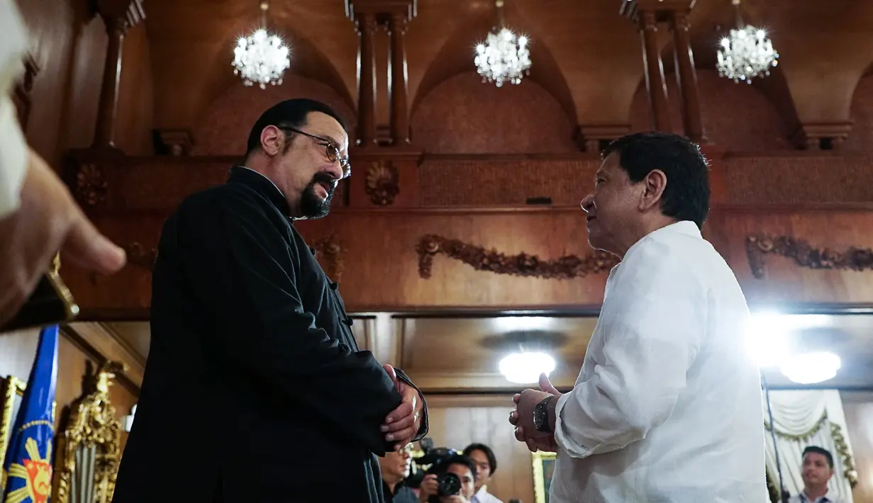 Presiden Filipina, Rodrigo Duterte berbincang dengan aktor AS, Steven Seagal yang melakukan kunjungan kehormatan di Istana Kepresidenan Malacanang, Manila, Kamis (12/10). Seagal berada di Filipina untuk mencari lokasi untuk film barunya (Handout/PPD/AFP)