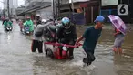 Pengendara sepeda motor menggunakan jasa angkut gerobak saat melintasi banjir yang merendam jalan KH Hasyim Ashari, Kota Tangerang, Banten, Sabtu (16/7/2022). Warga sekitar membantu para pengendara yang melintas agar tidak terkena banjir dengan menawarkan jasa gerobak. (Liputan6.com/Angga Yuniar)